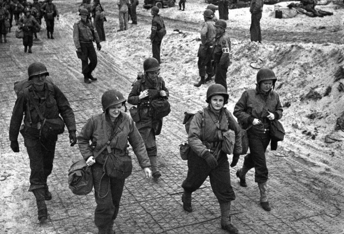 Các nữ y tá Mỹ đi bộ dọc bãi biển tại Normandy, Pháp, ngày 4/4/1944 sau khi xuống tàu đổ bộ. Họ đang trên đường tới bệnh viện để chăm sóc những binh sĩ bị thương. 