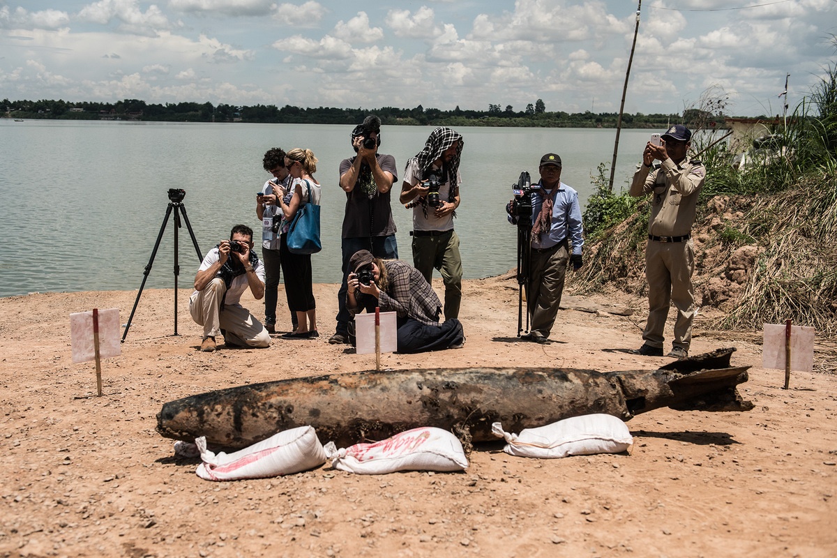 Các nhà báo chụp hình quả bom MK82 sau khi các thợ lặn trục vớt nó lên bờ. 