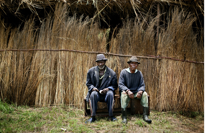 Hai người nông dân nghỉ ngơi trên băng ghế dài tại một nông trại ở gần thủ đô Harare. Nhiều gia đình tại Zimbabwe gắn bó với nghề nông trong 50 năm. 