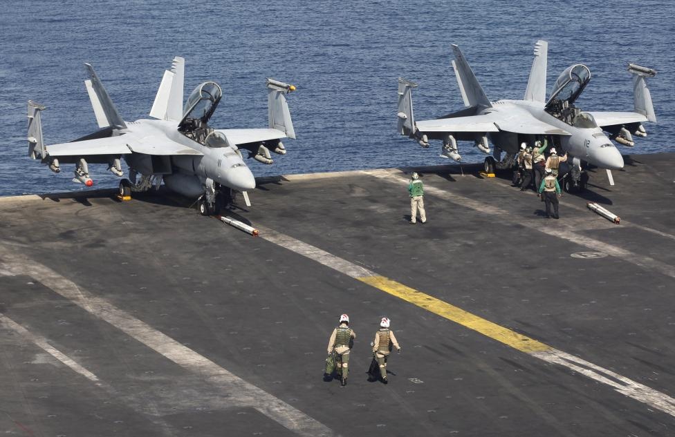 Các phi công của Hải quân Mỹ di chuyển lên máy bay để thực hiện nhiệm vụ.   