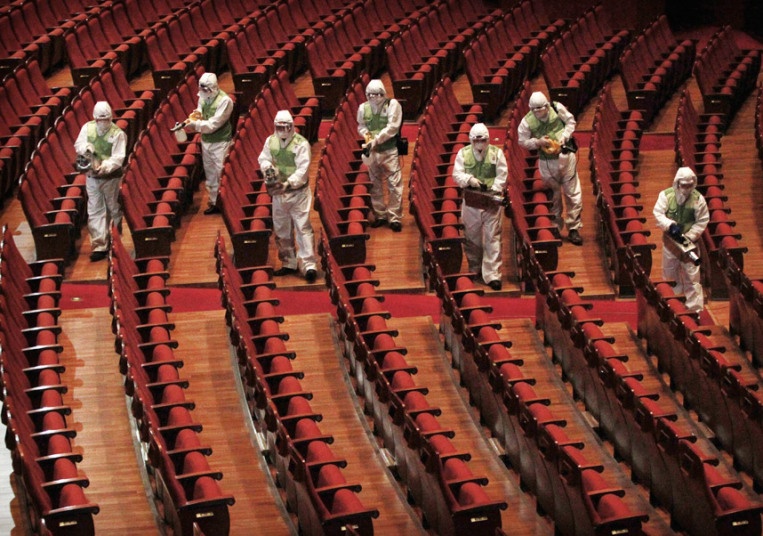 Nhân viên phòng hộ phun dung  dịch sát khuẩn tại Trung tâm Văn hóa Sejong ở Seoul, Hàn Quốc để phòng chống sự lây lan của virus Hội chứng hô hấp Trung Đông (MERS) đang lan rộng tại quốc gia này. Tính tới tối ngày 20/6, tổng số trường hợp thiệt mạng vì MERS tại Hàn Quốc là 25 người.