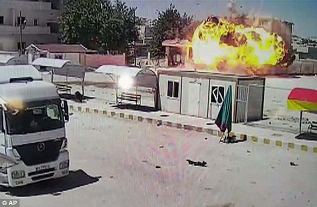 Lửa và khói bốc lên sau một vụ đánh bom xe do IS thực hiện. Tổ chức quan sát Nhân quyền Syria (SOHR) cho hay,  IS đã hành quyết 23 người Kurd, gồm phụ nữ và trẻ em tại Ayn al-Arab, ngôi làng phía nam thị trấn Kobane.