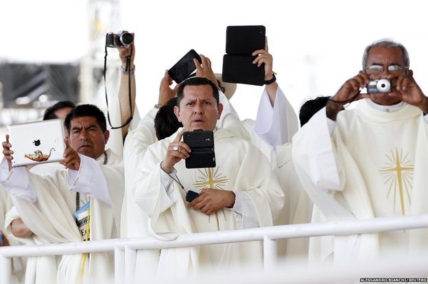 Các linh mục dùng máy ảnh, máy tính bảng, điện thoại ghi lại hình ảnh Đức giáo hoàng Francis khi ông chủ trì thánh lễ tại một công viên ở thành phố Guayaquil của Ecuador.