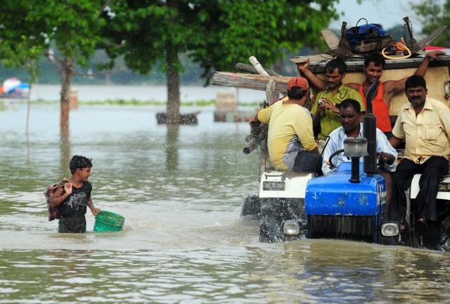 Người dân Indonesia di dời máy nông nghiệp tới khu vực an toàn sau khi lũ tấn công các vùng trũng ở nước này. 