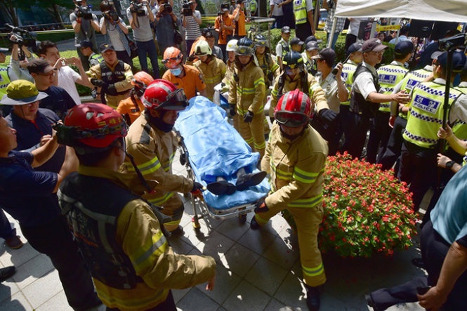 Ông Choi được lính cứu hỏa đưa đi cấp cứu sau khi tự thiêu. Ảnh: AFP
