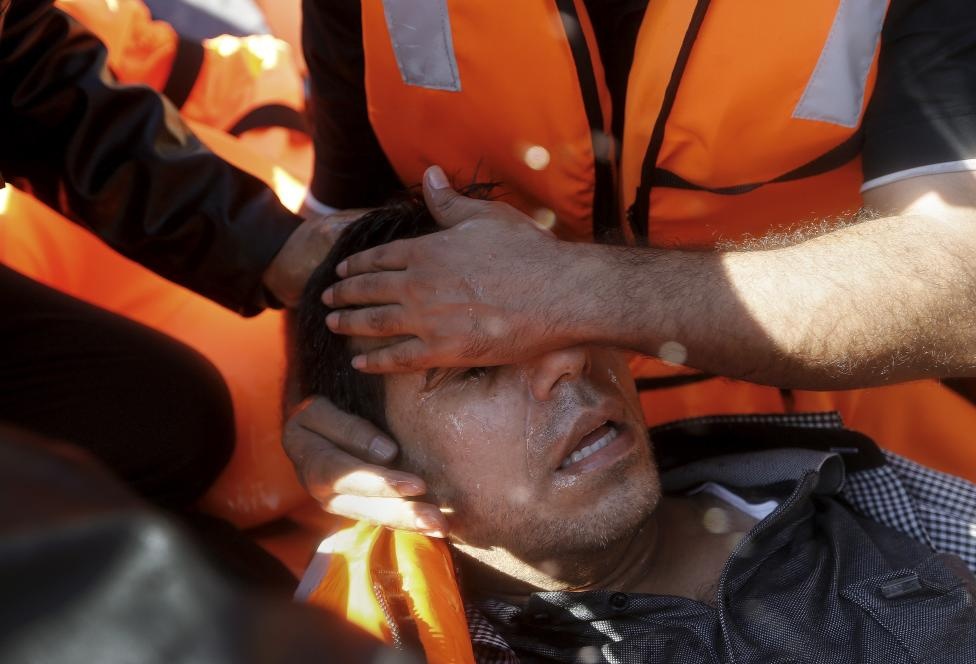 Một người đàn ông Syria kiệt sức sau chuyến vượt biển nguy hiểm. Ảnh: Reuters