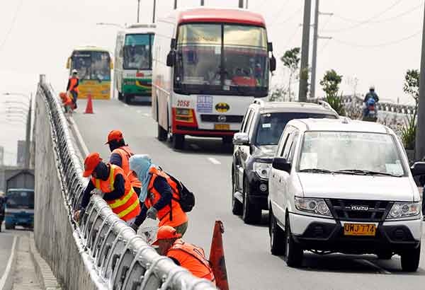 Các công nhân sơn mới thành cầu dọc đại lộ Roxas ở thành phố Passay hôm 2/11. Ảnh: Philstar