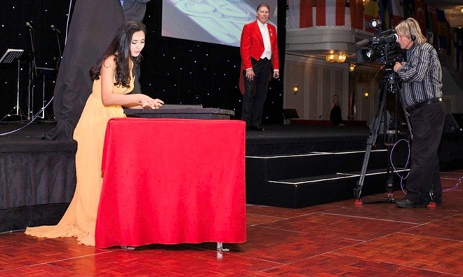 Nguyễn Thị Loan vẽ tranh cát trong đêm Gala từ thiện Hoa hậu Thế giới. Ảnh: Miss World