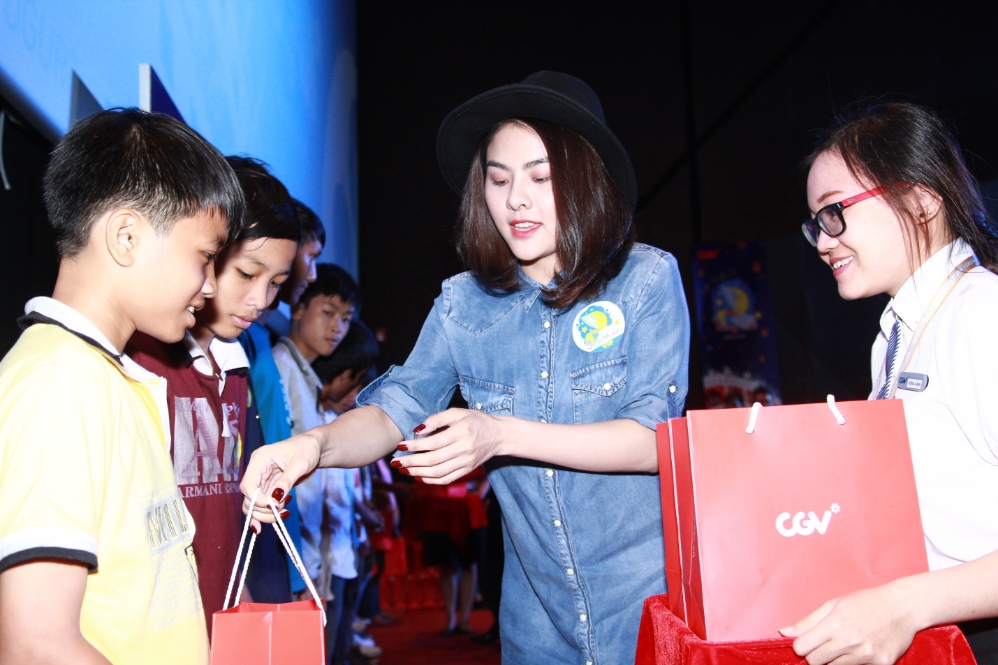 Người đẹp ân cần trao quà cho các bé thiếu nhi.