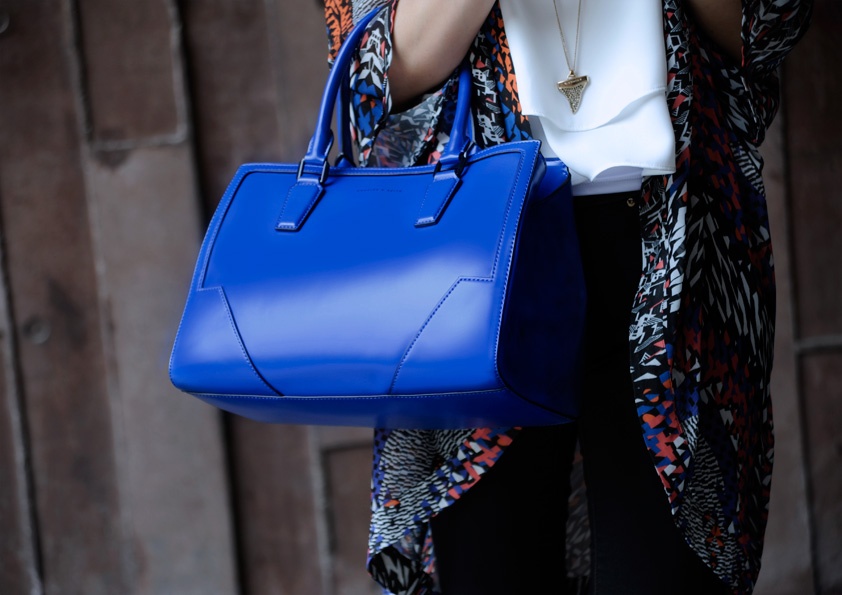 Chiếc túi xanh lục cùng màu với những chấm họa tiết trên áo choàng sẽ khiến bạn trở nên nổi bật trên đường phố.