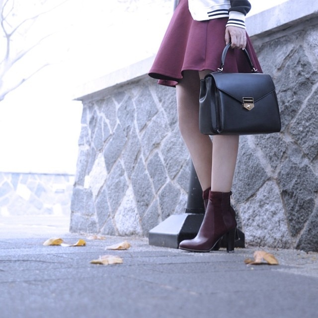 Đôi bốt kết hợp với chân váy màu đỏ burgundy nồng nàn cho một diện mạo thật ấm áp trong tiết trời se lạnh. 