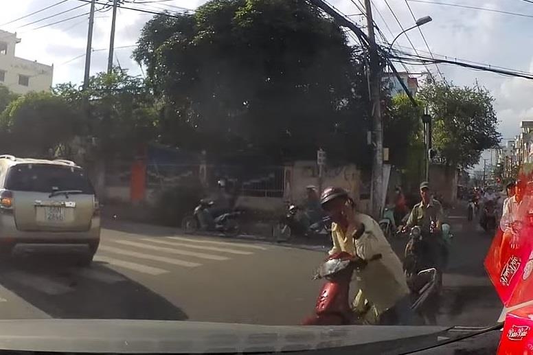 Nguoi di xe may tu nga tren duong vi su dung dien thoai hinh anh