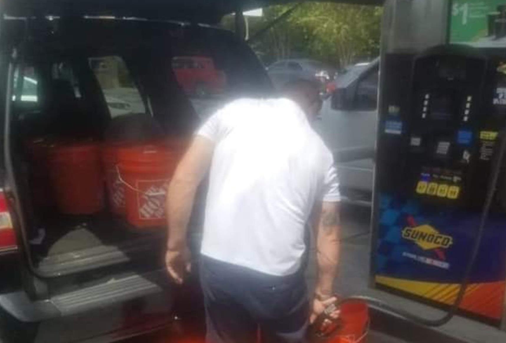 So bao ve, nguoi dan ong nay mang ca chuc thung nhua di mua xang hinh anh