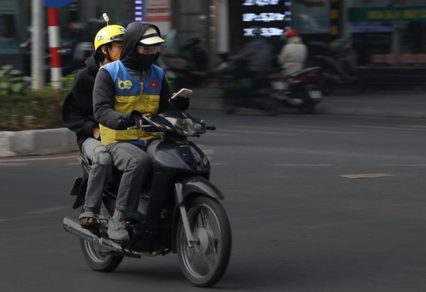 Tai xe xe om cong nghe dan mat vao dien thoai tren duong hinh anh