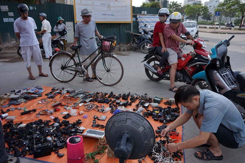 Đồ cũ đủ các loại được bày khá đơn giản trên những tấm bạt. Từ những chiếc điện thoại di động cũ rích đến tai nghe, sạc, dây cắm... đều được mua, bán.