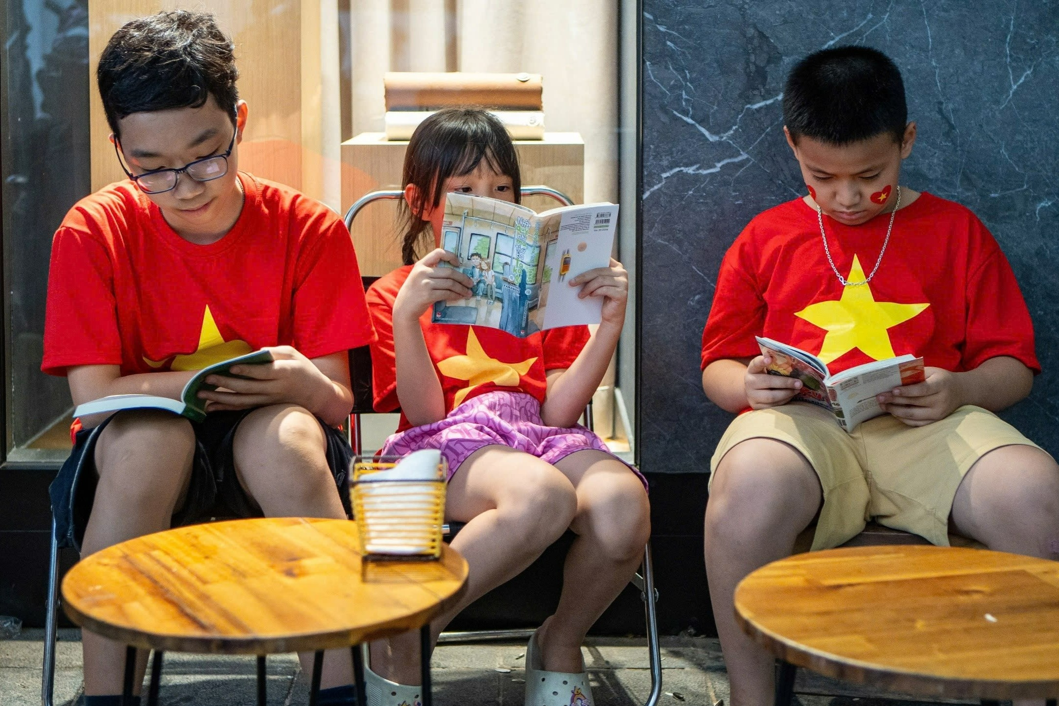 Nguoi dan doc sach trong luc cho xem duyet binh hinh anh