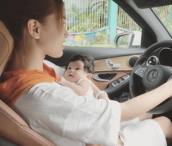 Hải Băng vừa bế con vừa lái xe ảnh 1 Hai Bang vua be con vua lai xe anh 1
