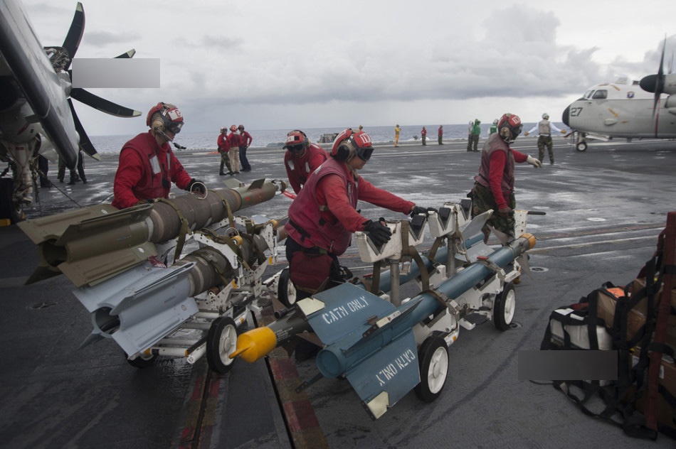 Các kỹ thuật viên đang gấp rút chuẩn bị vũ khí cho các tiêm kích trên hạm xuất kích