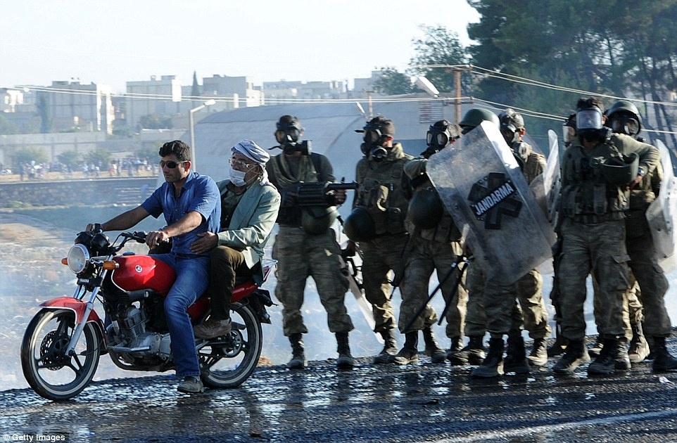 Nhân viên an ninh Thổ Nhĩ Kỳ dùng hơi cay để giải tán đám người tị nạn sau khi họ xô đổ hàng rào ở biên giới.