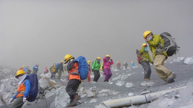 Bụi phủ kín bầu không khí xung quanh những người leo núi khi họ tháo chạy khỏi núi lửa Ontake hôm 27/9. Ảnh: Reuters