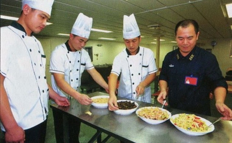 Một sĩ quan đang kiểm tra các món ăn sau khi chế biến xong.