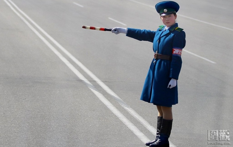 Nữ cảnh sát giao hướng dẫn giao thông cho các phương tiện khi đi qua quảng trường Kim Nhật Thành.