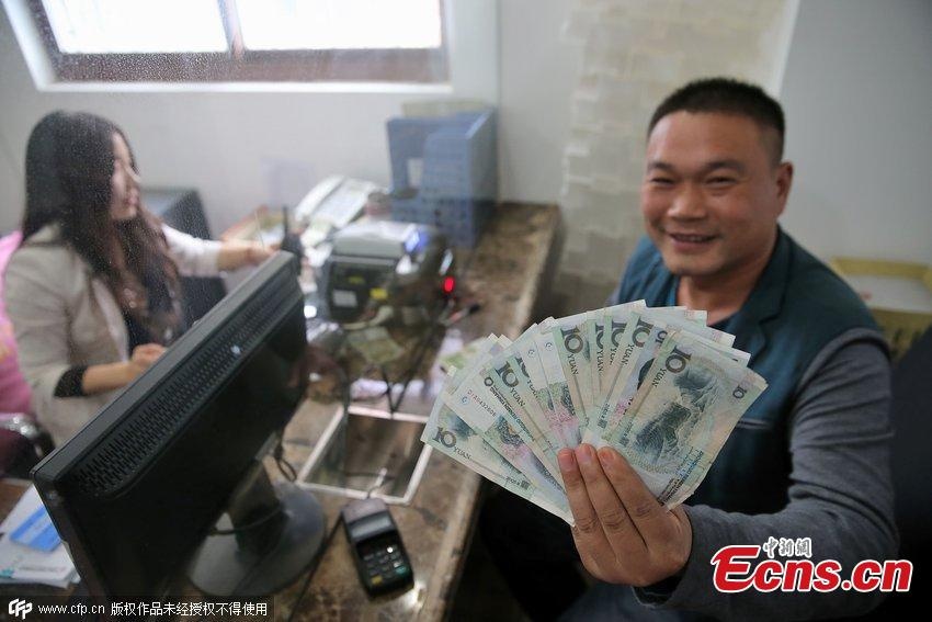 Một thanh niên giơ những đồng tiền mà anh tóm trong cuộc thi. 