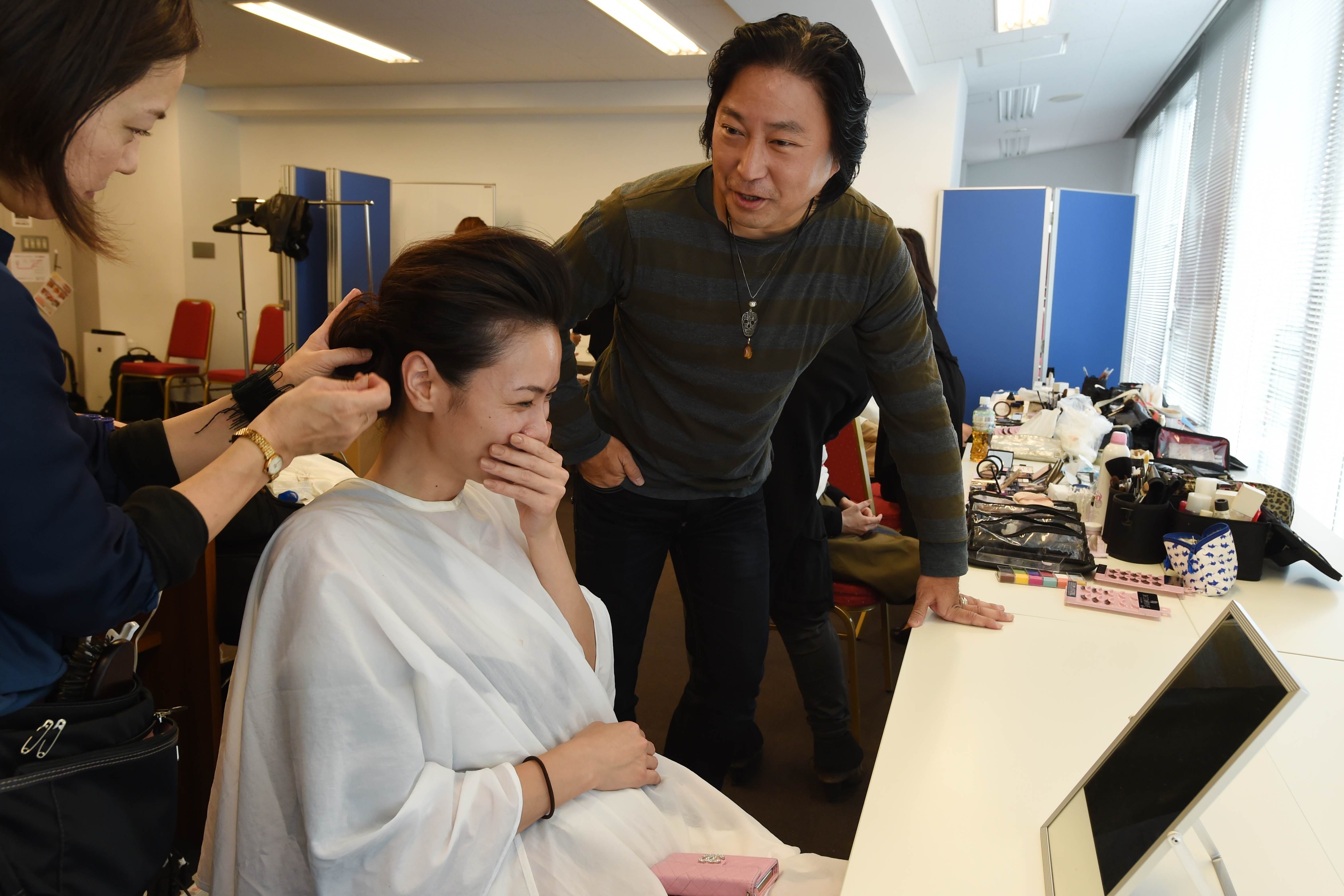 Nhà thiết kế Saito nói chuyện với người mẫu trong phòng trang điểm.
