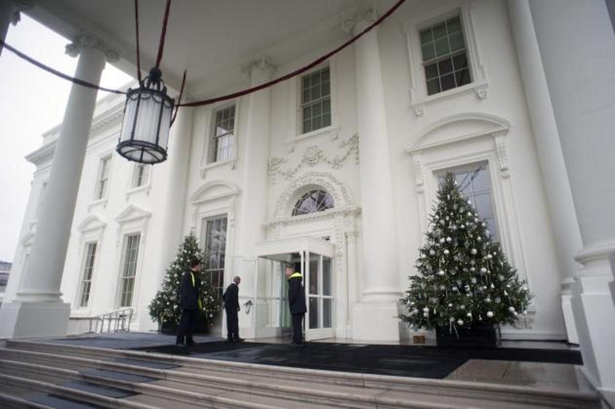 Nhân viên trang trí đặt cây thông Noel hai bên cửa vào tòa nhà North Portico.