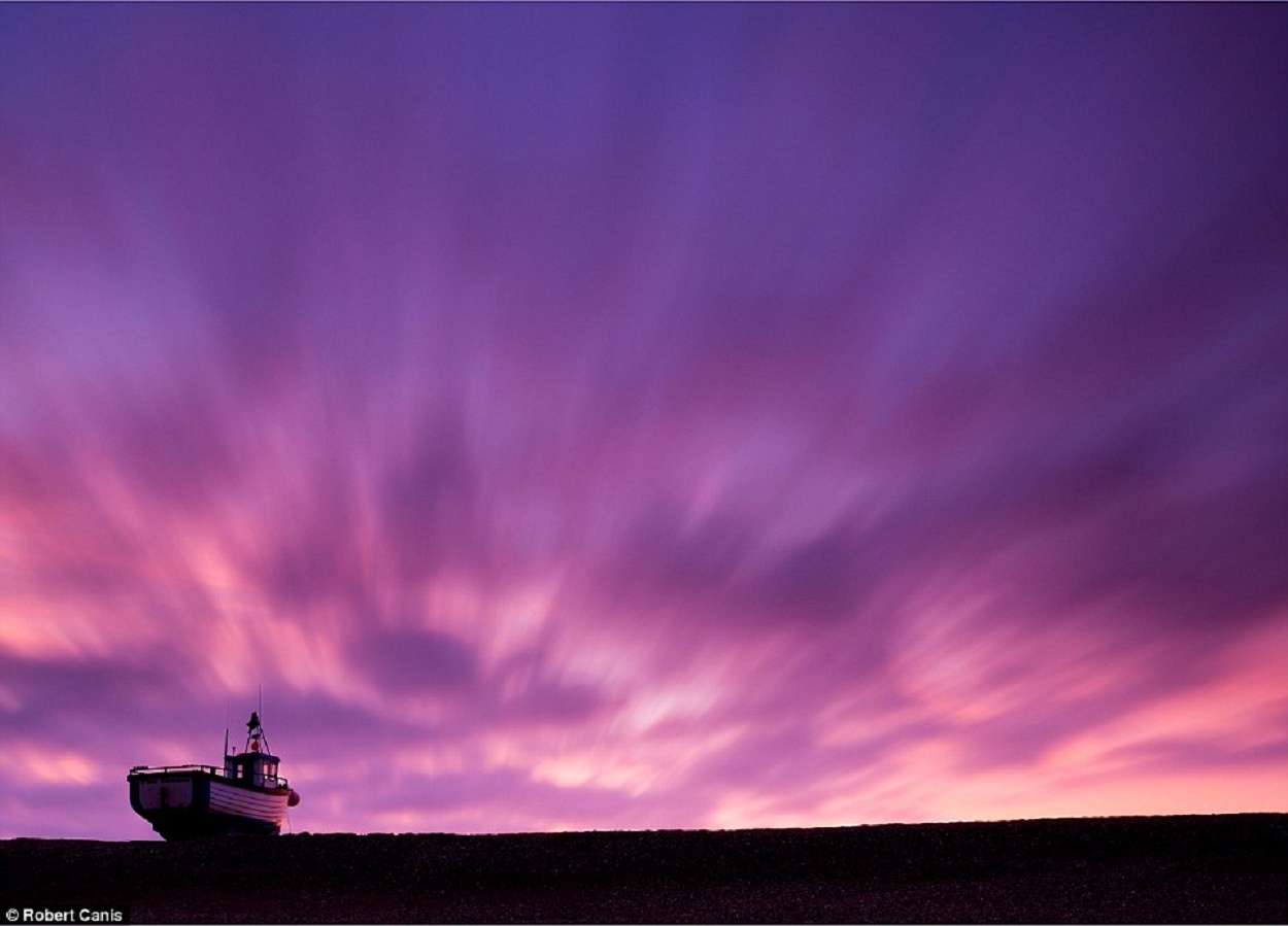 Bầu trời tím hồng trở thành phông nền tuyệt đẹp cho con thuyền thuyền đánh cá trên bờ đá cuội nhỏ lúc hoàng hôn ở bán đảo Dungeness, hạt Kent, Anh.