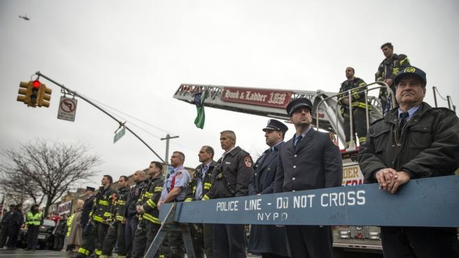 Hàng nghìn lính cứu hỏa đứng dọc hai bên đường để chờ linh cữu của Wenjian Liu. Ảnh: Reuters