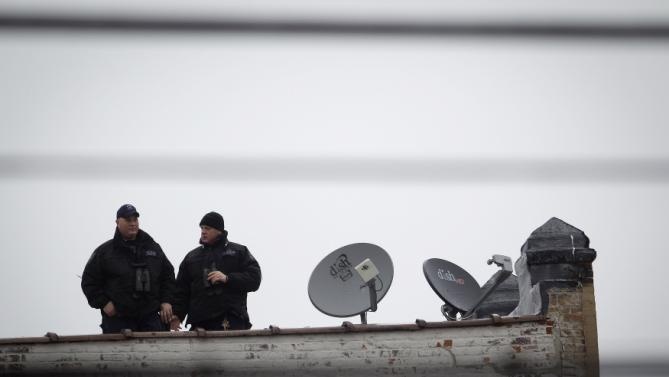 Xạ thủ bắn tỉa đứng trên một nóc nhà để bảo đảm an ninh cho tang lễ. Ảnh: 