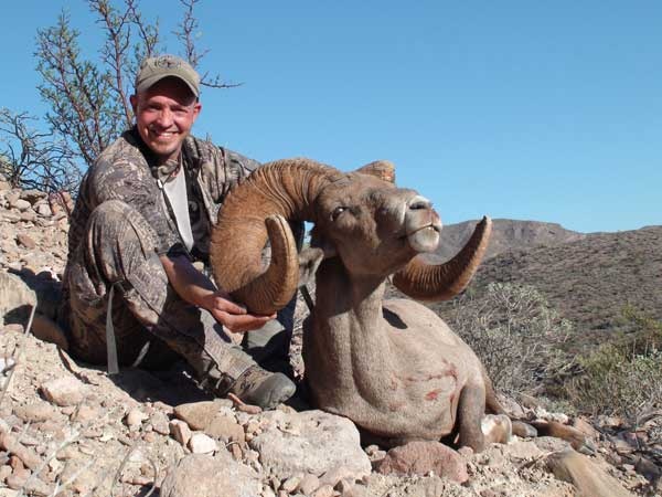 Một thợ săn chụp ảnh cùng con cừu sừng lớn trên đảo Tiburon của Mexico. Ảnh: hungtingreport.com