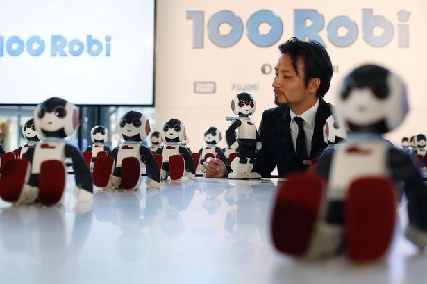 Nhà chế tạo robot Tomotaka Takahashi bên cạnh sản phẩm robot Robi của ông. Ảnh: Reuters