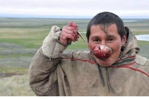 Một người đàn ông uống máu tuần lộc. Ảnh: