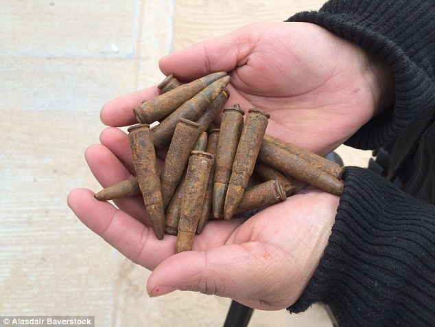 Một thanh tra cảnh sát ở thành phố San Agustin cho phóng viên xem những viên đạn rỉ mà ông bới trong lớp cát trong thành phố.