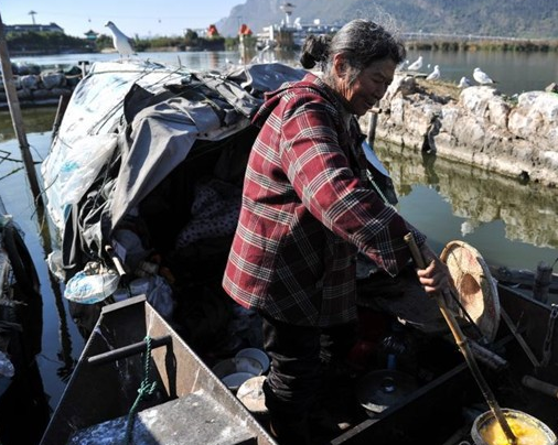 Nguoi phu nu neo don nhat rac de nuoi chim troi hinh anh