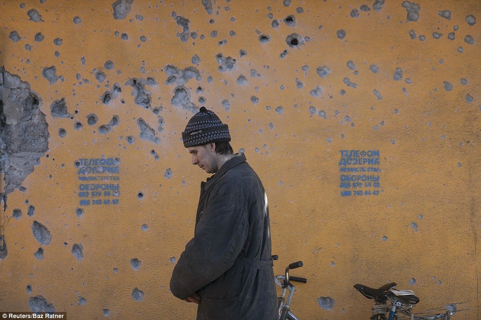 Hàng chục viên đạn găm vào bức tường gần vị trí của một người đàn ông chờ hàng cứu trợ.