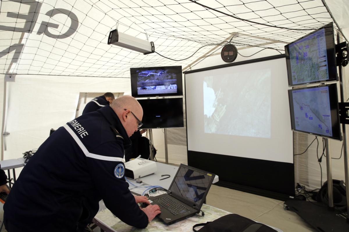 Một hiến binh nhập dữ liệu về nạn nhân vào máy tính trong lều gần hiện trường. Ảnh: EPA