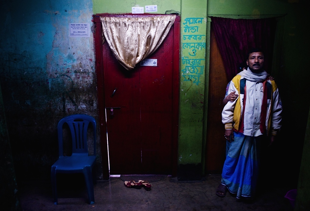 Một gái mại dâm trốn sau lưng khách hàng khi thấy máy ảnh.