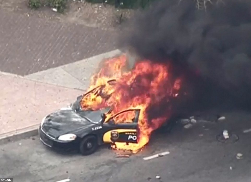 Những người quá kích châm lửa đốt xe cảnh sát. Ảnh: 