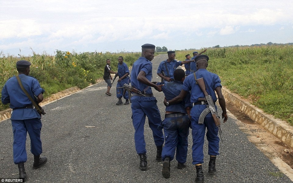 Hai cảnh sát dìu người phụ nữ sau khi đám đông ngừng đuổi theo cô.