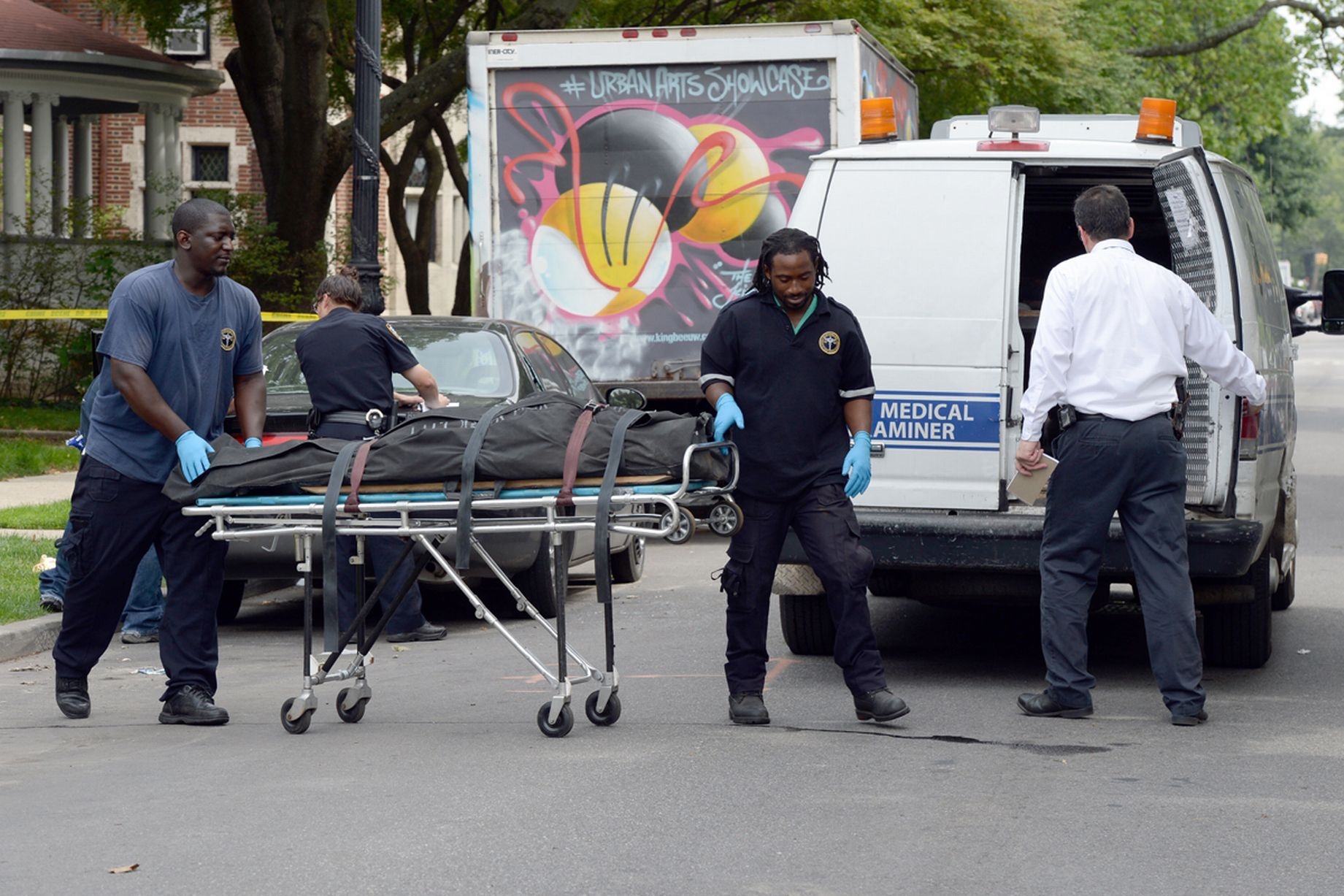 Nhân viên y tế đưa tử thi nạn nhân lên xe cứu thương.