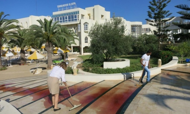 Nhân viên khách sạn lau máu trên các bậc thang. Ảnh: Guardian