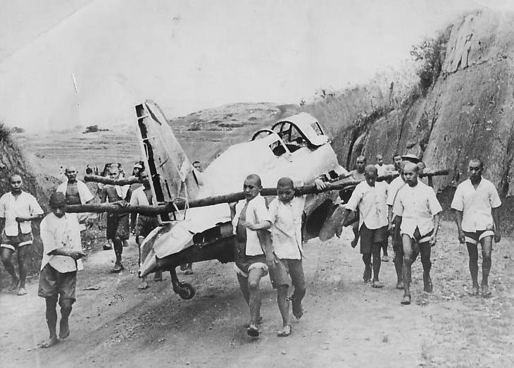 Nhóm thanh niên khiêng một máy bay Nhật tham gia chiến dịch ném bom thành phố Trùng Khánh vào năm 1940. Phi cơ rơi ở ngoại ô thành phố.