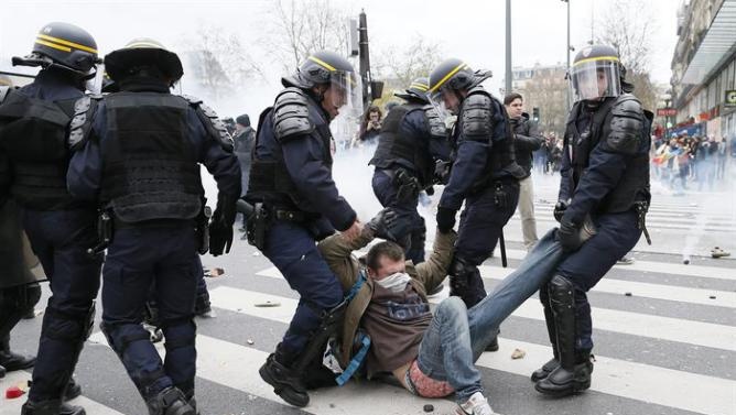 Cảnh sát chống bạo động bắt một thanh niên khi anh tham gia cuộc biểu tình phản đối COP21 tại quảng trường Republique, thành phố Paris hôm 29/11.