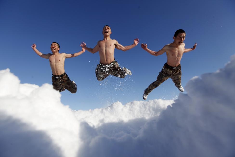 Binh sĩ Trung Quốc cởi trần và tập luyện trên tuyết khi nhiệt độ ngoài trời ở mức -26 độ C tại tỉnh Hắc Long Giang, nơi nằm gần biên giới Nga, hôm 14/12.