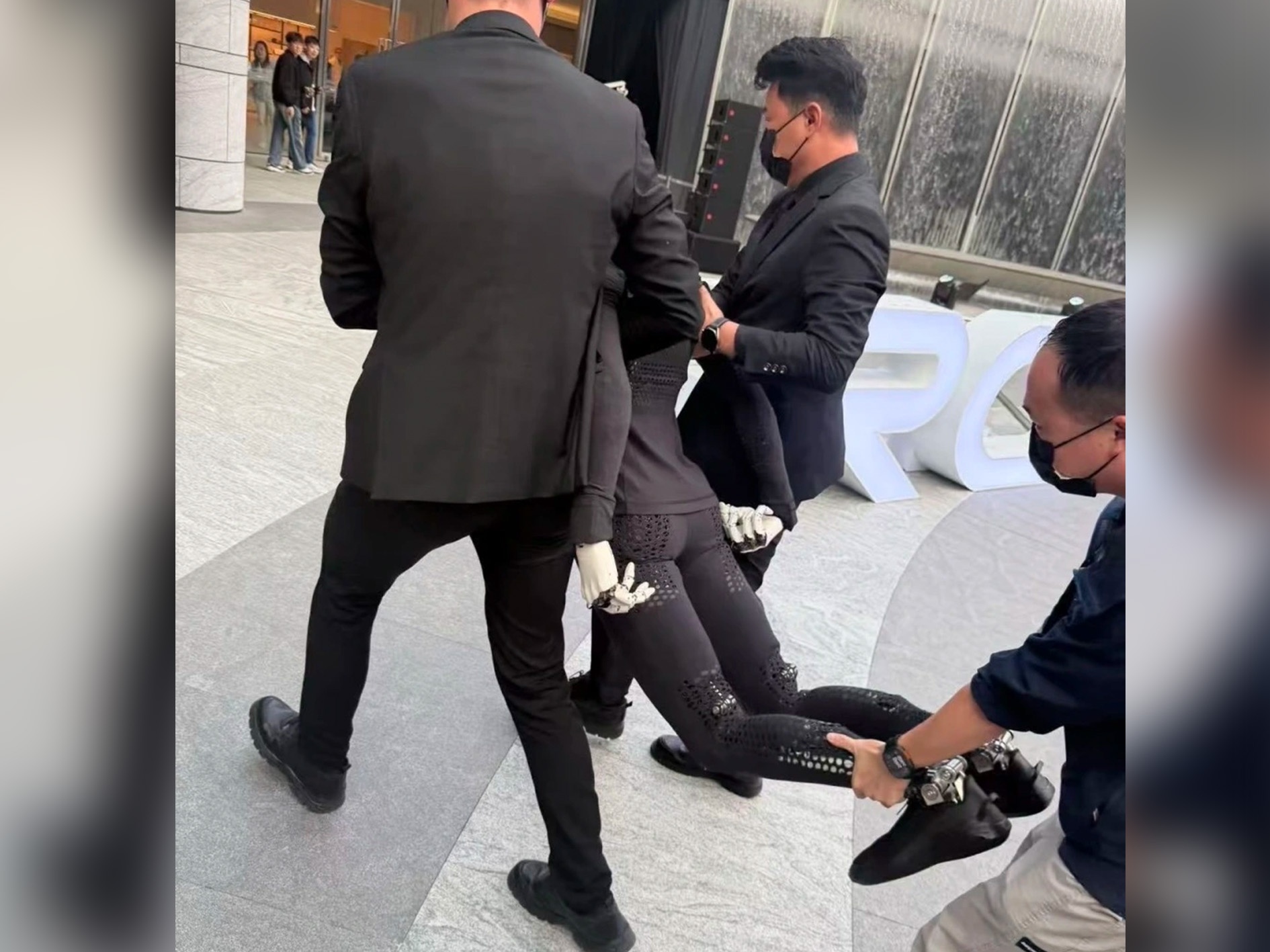 Robot Trung Quoc 'ngat xiu', bi 3 nguoi khieng khoi san khau hinh anh