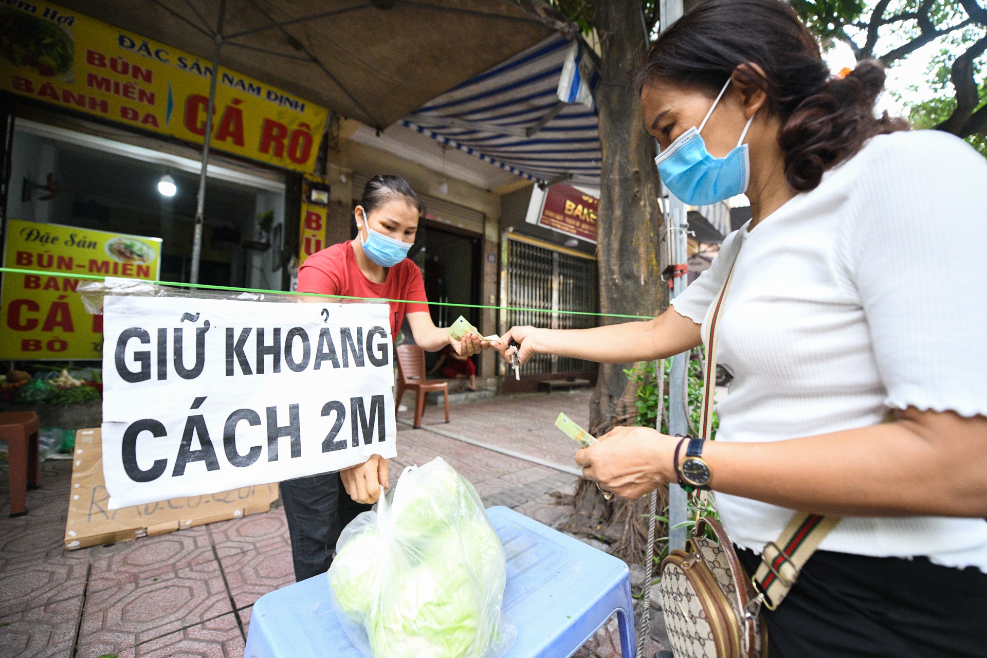 Phu nu nau com tang chot kiem dich covid-19,  Ha Noi gian cach anh 1