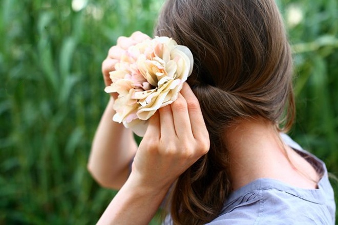 Cài kẹp hoa lên ngay trên phần thun buộc tóc.